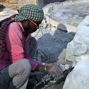 Local carver sculpting a bust without any protection equipment. The Stone dust affects carvers and their family members.